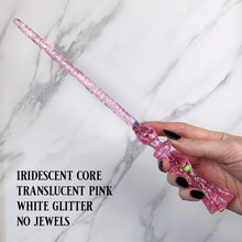Charger l'image dans la galerie, A stunning pink Flora magic wand featuring a delicate, translucent design with iridescent shimmering accents. The wand has a beautiful flower shaped base with a narrow shaft that sparkles in light, showcasing its intricate craftsmanship. Perfect for fantasy collectors, this wand embodies elegance and enchantment, making it a prized addition to any magical assortment.