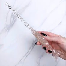 Load image into Gallery viewer, A stunning handcrafted Mertail magic wand made with shimmering rose quartz chips, showcasing a blend of pink hues. The wand has a gracefully tapered shaft that sparkles in light, showcasing its intricate craftsmanship. Perfect for fantasy collectors, this wand embodies elegance and enchantment, making it a prized addition to any magical assortment.