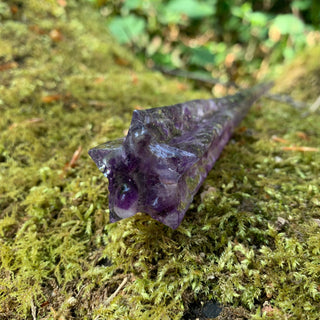 A unique handmade magic wand made with real purple amethyst crystal chips, in the Star  Design. 

The detailed end f the wand is a five pointed star shape and is on a moss covered background. 