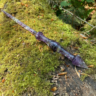 A unique handmade magic wand made with real purple amethyst crystal chips, in the Stiletto  Design. 

The background is a mossy log in the woods