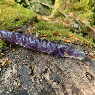 A unique handmade magic wand made with real purple amethyst crystal chips, in the Twist  Design. 

The detail of the twisted handle os on a moss covered log in a  forest. 