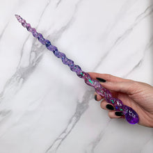 Load image into Gallery viewer, A stunning pink and purple unicorn magic wand featuring a delicate, translucent design with iridescent shimmering accents and glitter. The wand has a gracefully tapered shaft that sparkles in light, showcasing its intricate craftsmanship. Perfect for fantasy collectors, this wand embodies elegance and enchantment, making it a prized addition to any magical assortment.
