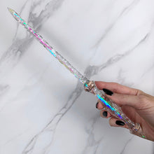 Load image into Gallery viewer, A stunning clear Stiletto design magic wand featuring a delicate, translucent design with iridescent shimmering accents. The wand has a beautiful smooth handle that tapers to a point with a narrow shaft that sparkles in light, showcasing its intricate craftsmanship. Perfect for fantasy collectors, this wand embodies elegance and enchantment, making it a prized addition to any magical assortment.
