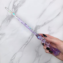 Charger l&#39;image dans la galerie, A stunning clear and purple Flora magic wand featuring a delicate, translucent design with iridescent shimmering accents. The wand has a beautiful flower shaped base with a narrow shaft that sparkles in light, showcasing its intricate craftsmanship. Perfect for fantasy collectors, this wand embodies elegance and enchantment, making it a prized addition to any magical assortment.
