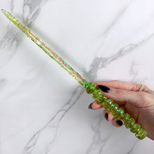 Load image into Gallery viewer, A stunning lime green celestial-inspired Orbit design magic wand featuring a delicate, translucent design with iridescent shimmering accents. The wand has a beautiful handle with alternating hoops with a narrow shaft that sparkles in light, showcasing its intricate craftsmanship. Perfect for fantasy collectors, this wand embodies elegance and enchantment, making it a prized addition to any magical assortment.
