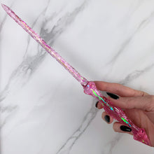 Charger l&#39;image dans la galerie, A stunning pink Stiletto design magic wand featuring a delicate, translucent design with iridescent shimmering accents. The wand has a beautiful smooth handle that tapers to a point with a narrow shaft that sparkles in light, showcasing its intricate craftsmanship. Perfect for fantasy collectors, this wand embodies elegance and enchantment, making it a prized addition to any magical assortment.
