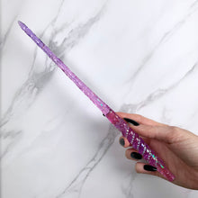 Lade das Bild in den Galerie-Viewer, A stunning purple and pink Twist design magic wand featuring a delicate, translucent design with iridescent shimmering accents. The wand has a beautiful twisted handle with with a narrow shaft that sparkles in light, showcasing its intricate craftsmanship. Perfect for fantasy collectors, this wand embodies elegance and enchantment, making it a prized addition to any magical assortment.
