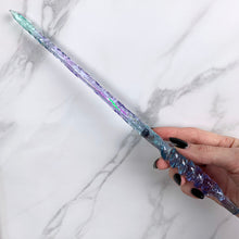 Charger l&#39;image dans la galerie, A stunning teal and purple Twist design magic wand featuring a delicate, translucent design with iridescent shimmering accents. The wand has a beautiful twisted handle with with a narrow shaft that sparkles in light, showcasing its intricate craftsmanship. Perfect for fantasy collectors, this wand embodies elegance and enchantment, making it a prized addition to any magical assortment.
