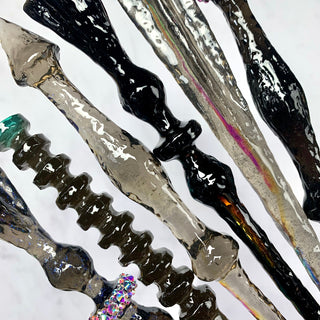 Close of of magic wands in various shades of black and grey on a white background.