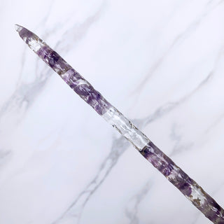 A unique handmade magic wand made with real purple amethyst crystal chips, in the Stiletto  Design. 

The detail of the tip of the wand is on a white marbled background.