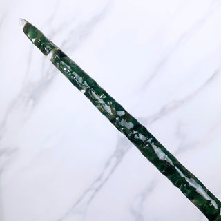 A unique handmade magic wand made with real green aventurine crystal chips, in the Orbit  Design. 

On a white marbled background.