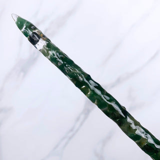 A unique handmade magic wand made with real green aventurine crystal chips, in the Stiletto  Design. 

On a white marbled background.