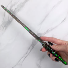 Load image into Gallery viewer, A stunning black Twist design magic wand featuring a delicate, translucent design with iridescent shimmering accents. The wand has a beautiful twisted handle with with a narrow shaft that sparkles in light, showcasing its intricate craftsmanship. Perfect for fantasy collectors, this wand embodies elegance and enchantment, making it a prized addition to any magical assortment.
