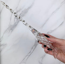 Load image into Gallery viewer, A stunning clear Mermaid inspired magic wand featuring a delicate, translucent design with iridescent shimmering accents. The wand has a beautiful fishtail shaped base with a swirling shaft that sparkles in light, showcasing its intricate craftsmanship. Perfect for fantasy collectors, this wand embodies elegance and enchantment, making it a prized addition to any magical assortment.

