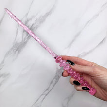 Load image into Gallery viewer, A stunning pink celestial-inspired Orbit design magic wand featuring a delicate, translucent design with iridescent shimmering accents. The wand has a beautiful handle with alternating hoops with a narrow shaft that sparkles in light, showcasing its intricate craftsmanship. Perfect for fantasy collectors, this wand embodies elegance and enchantment, making it a prized addition to any magical assortment.
