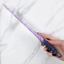 Lade das Bild in den Galerie-Viewer, A stunning purple Twist design magic wand featuring a delicate, translucent design with iridescent shimmering accents. The wand has a beautiful twisted handle with with a narrow shaft that sparkles in light, showcasing its intricate craftsmanship. Perfect for fantasy collectors, this wand embodies elegance and enchantment, making it a prized addition to any magical assortment.
