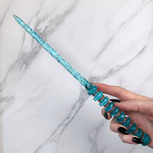 Charger l&#39;image dans la galerie, A stunning teal and orange celestial-inspired Orbit design magic wand featuring a delicate, translucent design with iridescent shimmering accents. The wand has a beautiful handle with alternating hoops with a narrow shaft that sparkles in light, showcasing its intricate craftsmanship. Perfect for fantasy collectors, this wand embodies elegance and enchantment, making it a prized addition to any magical assortment.

