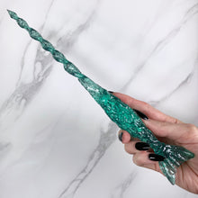 Charger l&#39;image dans la galerie, A stunning green Mermaid inspired magic wand featuring a delicate, translucent design with iridescent shimmering accents. The wand has a beautiful fishtail shaped base with a swirling shaft that sparkles in light, showcasing its intricate craftsmanship. Perfect for fantasy collectors, this wand embodies elegance and enchantment, making it a prized addition to any magical assortment.

