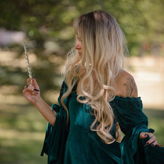 witch with green dress holding a clear unicorn shaped magic wand